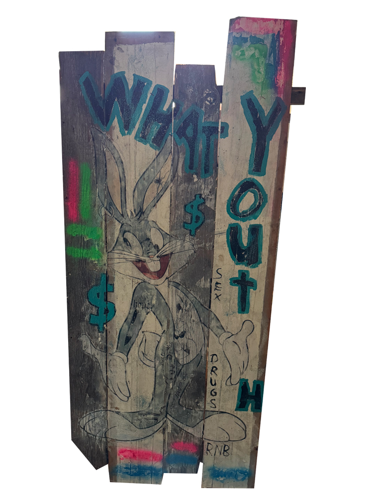 Skulpturales Urban-Pop-Art-Kunstwerk auf einer 80 Jahre alten, verwitterten Holztür aus vertikalen Planken. Es zeigt im Zentrum das aufgedruckte Motiv von Bugs Bunny. Darüber prangt der blaue Graffiti-Schriftzug „WHAT’S UP TO H“ mit einem Kreuz-Symbol. Der Hintergrund ist mit Dollarzeichen, neonfarbenen Farbakzenten und den Wörtern „SEX“, „DRUGS“ und „RNB“ gestaltet.
